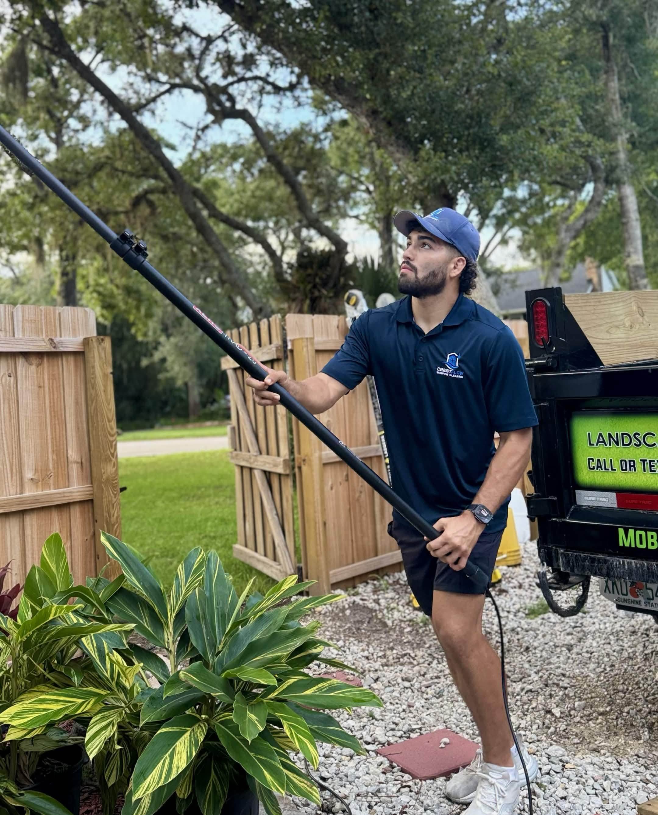 CrestFlow technician extending a water-fed pole beside the company trailer